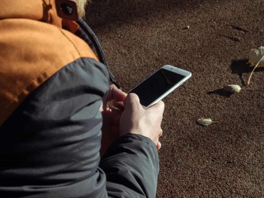 Side View Of Boy Playing With Iphone